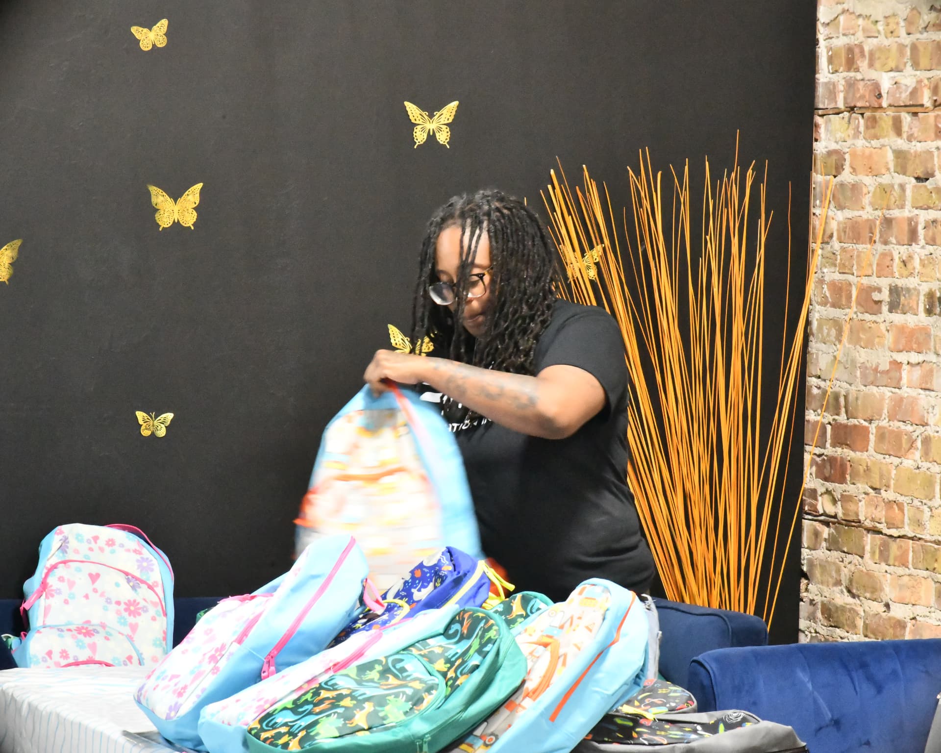 Volunteer filling backpacks with school supplies for the Back to School Bash