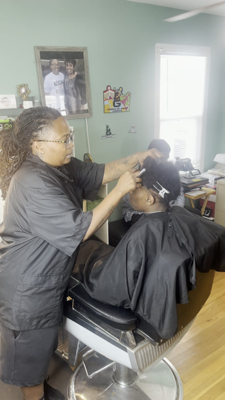 Moe the Barber giving a young man a fresh haircut in the FMG shop
